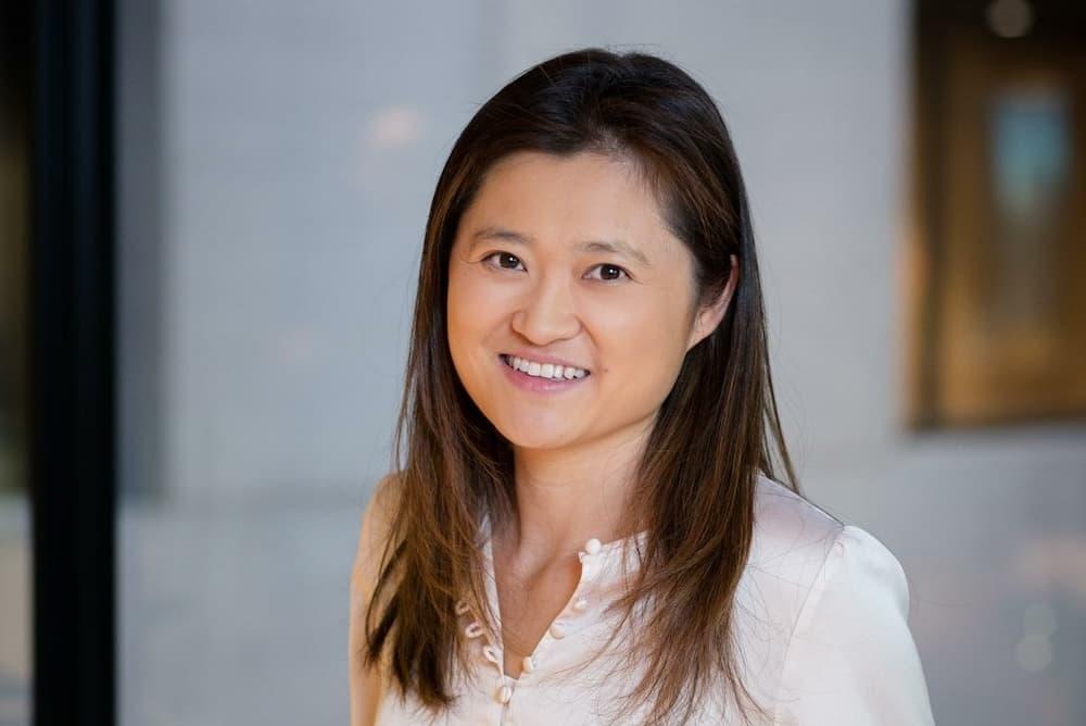 A headshot of Merlin's Chief Strategy Officer, Linda, in a pale satin shirt and trousers.