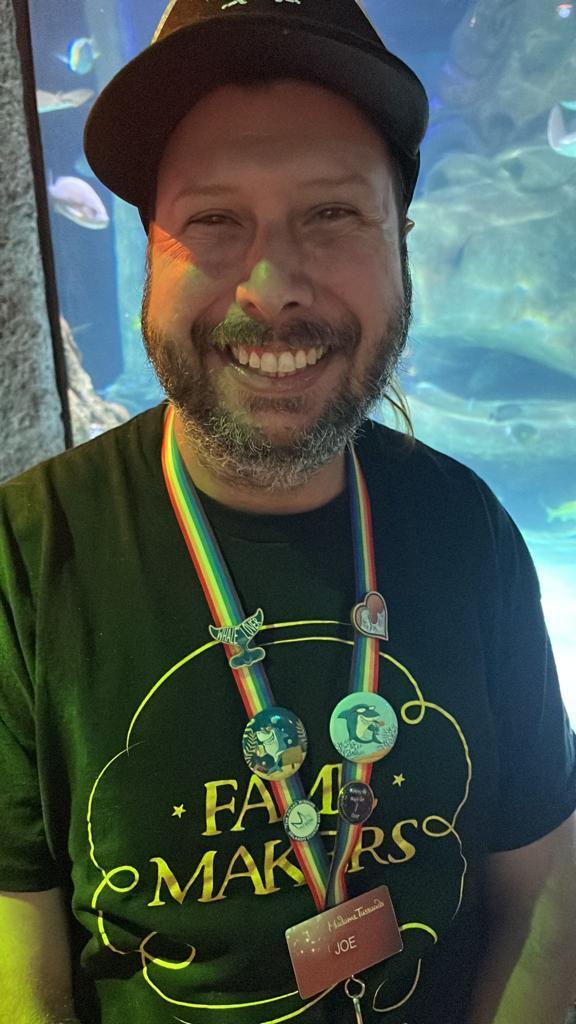 Joe standing in front of an aquarium smiling